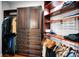 Wooden walk-in closet featuring custom shelving, hanging rods, and lots of storage space at 10712 Pontofino Cir, Trinity, FL 34655