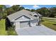 Aerial view of home with a spacious driveway, well-maintained landscaping, and mature trees at 11253 Avalon Way, Spring Hill, FL 34609