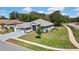 Aerial view showcasing a house with green lawn and mature trees near a road and sidewalk at 11253 Avalon Way, Spring Hill, FL 34609