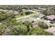 This aerial view showcases a peaceful home in a quiet neighborhood surrounded by green spaces and trees at 11253 Avalon Way, Spring Hill, FL 34609