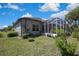 Home exterior featuring a screened-in lanai and a well-maintained lawn and landscaping at 11253 Avalon Way, Spring Hill, FL 34609