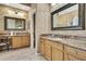 Spacious bathroom featuring double sinks, granite countertops and neutral marble tiled walls at 11253 Avalon Way, Spring Hill, FL 34609