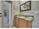 Well-lit bathroom featuring a granite vanity and door to the outside at 11253 Avalon Way, Spring Hill, FL 34609