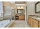 Elegant bathroom with marble finishes, glass enclosed shower, and separate soaking tub at 11253 Avalon Way, Spring Hill, FL 34609