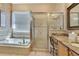 Bathroom with large soaking tub, glass enclosed shower, and granite countertops at 11253 Avalon Way, Spring Hill, FL 34609