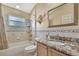 Well-lit bathroom features a tub and shower combination, single sink vanity with granite countertops at 11253 Avalon Way, Spring Hill, FL 34609