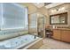Bright bathroom featuring a soaking tub, glass-enclosed shower, and neutral tile finishes at 11253 Avalon Way, Spring Hill, FL 34609