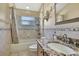 Bathroom with granite countertops, tub and shower combination, and decorative mirror and lighting at 11253 Avalon Way, Spring Hill, FL 34609