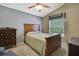 Bedroom featuring a wooden bed frame, ceiling fan, and a large window for natural light at 11253 Avalon Way, Spring Hill, FL 34609