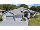 Charming single-story home featuring a well-manicured lawn and a three-car garage at 11253 Avalon Way, Spring Hill, FL 34609