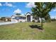 Well-manicured front yard with lush green grass and mature trees in front of a charming house at 11253 Avalon Way, Spring Hill, FL 34609