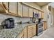 Kitchen featuring granite countertops, wood cabinets, and stainless appliances at 11253 Avalon Way, Spring Hill, FL 34609