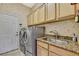 Laundry room features stainless steel washer/dryer, granite sink, and ample storage at 11253 Avalon Way, Spring Hill, FL 34609