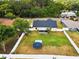 A bird's eye view of a large backyard with a trampoline and above ground pool enclosed by a white picket fence at 11630 Pasadena Rd, Dade City, FL 33525