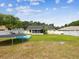 Expansive backyard featuring a trampoline, inflatable pool, and white perimeter fence at 11630 Pasadena Rd, Dade City, FL 33525