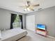 This bedroom offers a ceiling fan, closet, and window with beautiful gray walls and neutral carpet at 11630 Pasadena Rd, Dade City, FL 33525