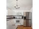 Bright kitchen with white cabinets, stainless steel refrigerator, and hardwood floors at 11630 Pasadena Rd, Dade City, FL 33525