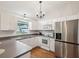 Bright kitchen featuring white cabinets, stainless steel refrigerator, and hardwood floors at 11630 Pasadena Rd, Dade City, FL 33525