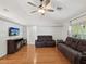 Cozy living room featuring hardwood floors, a ceiling fan, and comfortable leather seating at 11630 Pasadena Rd, Dade City, FL 33525