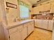 Bright kitchen featuring white cabinets, laminate countertops, and a garden window at 11814 Carissa Ln, New Port Richey, FL 34654