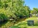 Picturesque view of a tranquil canal surrounded by lush vegetation, showcasing the natural beauty of the property at 11814 Carissa Ln, New Port Richey, FL 34654