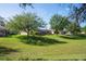 The home's large, grassy backyard is adjacent to the pool area, surrounded by mature shade trees and landscaping at 11949 Wexford Blvd, Spring Hill, FL 34609