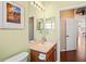 Bathroom vanity with wood cabinet, single sink, and mirror, leading to an open doorway to the rest of the home at 11949 Wexford Blvd, Spring Hill, FL 34609
