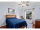 Cozy bedroom with a bed, a window overlooking a patio, hardwood floors, and a ceiling fan at 11949 Wexford Blvd, Spring Hill, FL 34609