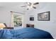 Relaxing bedroom featuring a bed with a blue comforter, a ceiling fan, and a patio view at 11949 Wexford Blvd, Spring Hill, FL 34609