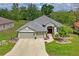 Charming single-story home featuring a well-manicured lawn, lovely landscaping, and a three-car garage at 11949 Wexford Blvd, Spring Hill, FL 34609