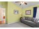 Comfortable living room with a gray couch, light-green walls, and an open doorway at 11949 Wexford Blvd, Spring Hill, FL 34609
