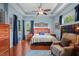 Primary suite features a ceiling fan, tray ceiling, access to a pool, and hardwood floors at 11949 Wexford Blvd, Spring Hill, FL 34609