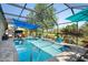 The screened-in pool area offers a great space with a pool, blue awning, mature landscaping, and open views at 11949 Wexford Blvd, Spring Hill, FL 34609