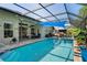 The screened-in pool with a blue awning offers a refreshing escape and a nice area for entertaining at 11949 Wexford Blvd, Spring Hill, FL 34609
