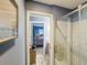 Bathroom with modern shower and view into an adjacent bedroom at 12545 Dearborn Dr # D, Bayonet Point, FL 34667