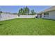 This large backyard, enclosed by a white fence, offers ample space for a variety of outdoor activities and grilling at 13160 Golden Lime Ave, Spring Hill, FL 34609