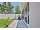 This view of the fenced in yard shows a small grilling patio just outside the screened in porch at 13160 Golden Lime Ave, Spring Hill, FL 34609