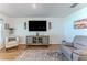 Bright living room with a wall-mounted TV, gray accent rug, and stylish furnishings at 13160 Golden Lime Ave, Spring Hill, FL 34609