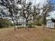 Spacious backyard featuring mature trees and a view of the home with an enclosed back porch at 13377 Montour St, Brooksville, FL 34613