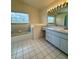 Bright bathroom features a large vanity with ample countertop space and a separate bathtub at 13377 Montour St, Brooksville, FL 34613