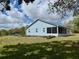 Back exterior features a screened-in porch and lush green lawn that creates a serene setting at 13377 Montour St, Brooksville, FL 34613