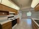 Kitchen with wooden cabinets, tile flooring, and appliances; leads to the dining area at 13377 Montour St, Brooksville, FL 34613