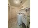 Well-lit laundry room featuring a washer, dryer, utility sink, and ample storage shelving at 13377 Montour St, Brooksville, FL 34613