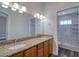 Bathroom featuring double sinks, granite countertops, and a glass-enclosed shower at 13741 Judy Ave, Hudson, FL 34667