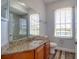 Bathroom with a granite countertop, a white toilet, and a large mirror at 13741 Judy Ave, Hudson, FL 34667