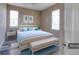 Bright bedroom with a window, bench, and bed dressed in light blue bedding at 13741 Judy Ave, Hudson, FL 34667