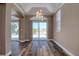 Bright dining room featuring dark wood floors, a modern chandelier, and sliding glass doors to a balcony at 13741 Judy Ave, Hudson, FL 34667