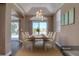 Elegant dining room with a modern chandelier, a large window, and comfortable seating for six at 13741 Judy Ave, Hudson, FL 34667