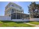 Exterior of a three-story home with a screened-in patio and multiple balconies at 13741 Judy Ave, Hudson, FL 34667