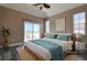 Bright bedroom with a king size bed, a ceiling fan, and sliding glass doors to a balcony at 13741 Judy Ave, Hudson, FL 34667